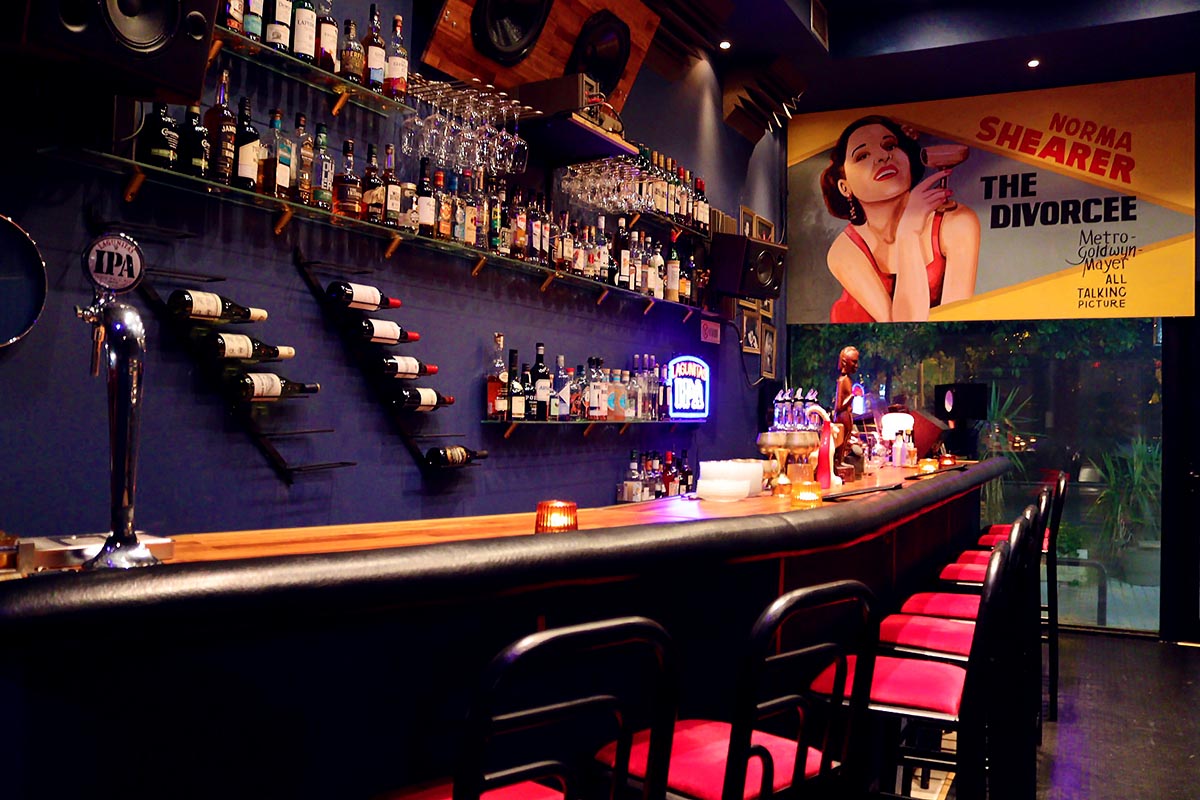 Wooden bar and noir cinema poster inside Finos